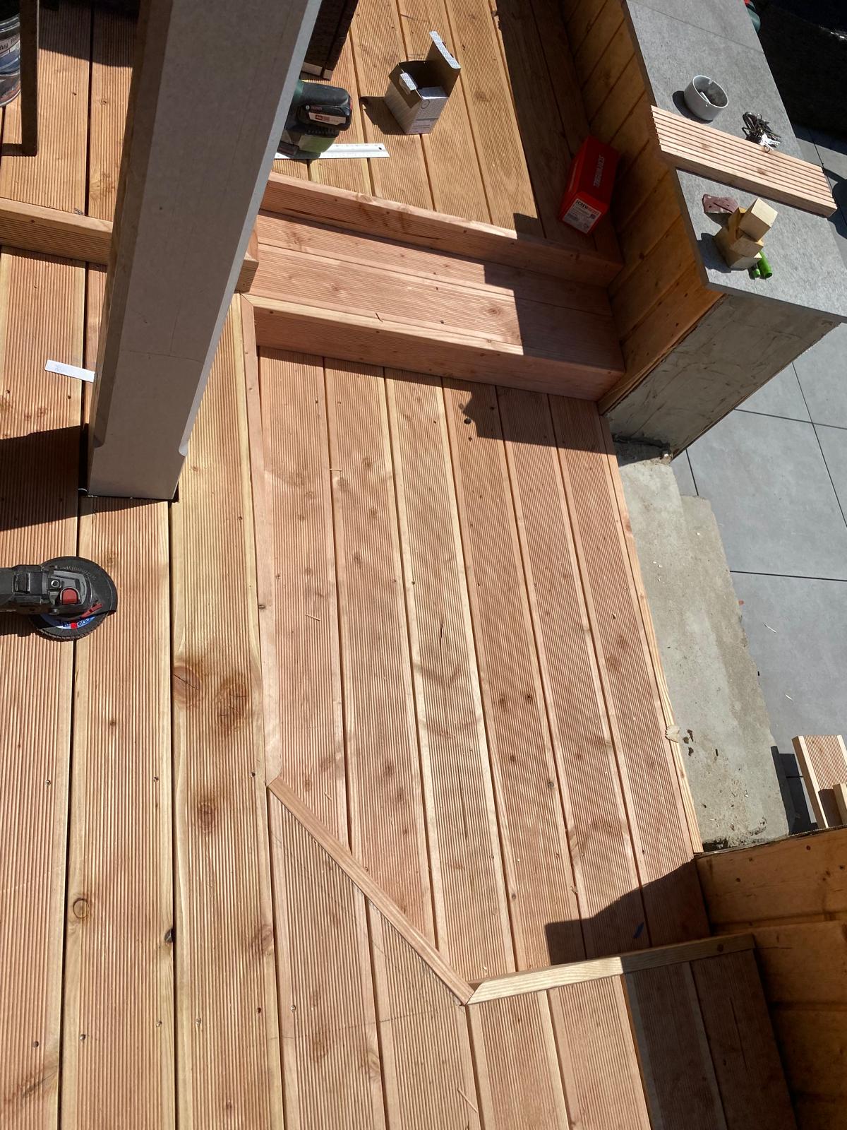 Ausführung einer Holzterrasse mit zugeschnittenen Dielen und Stufen