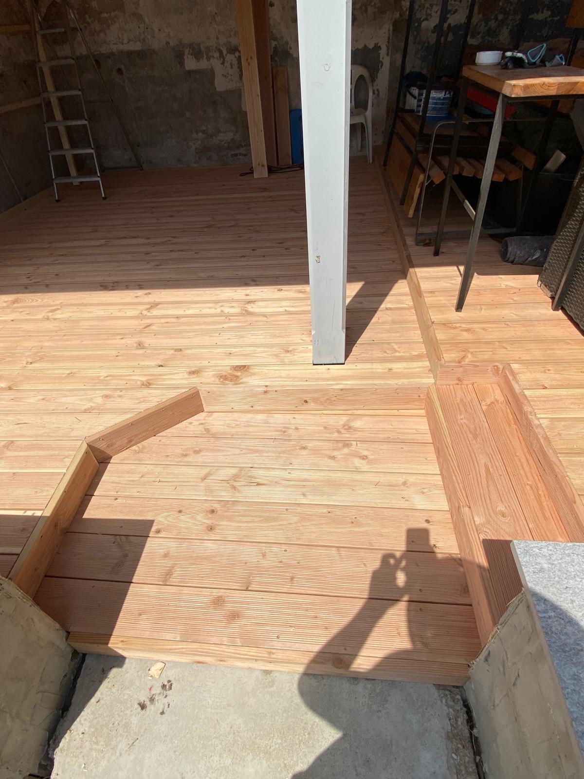 Detail einer fertiggestellten Holzterrasse mit passgenauen Stufen und Übergängen