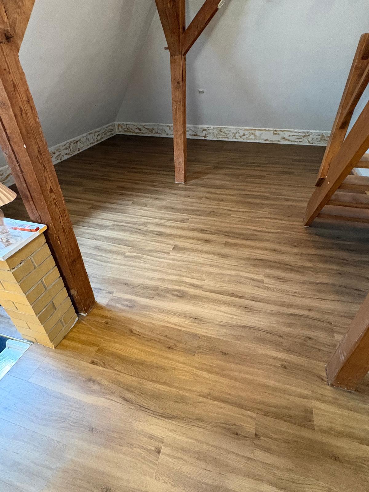Warmer Vinylboden mit passgenauen Anschlüssen an sichtbares Fachwerk und eine Treppe