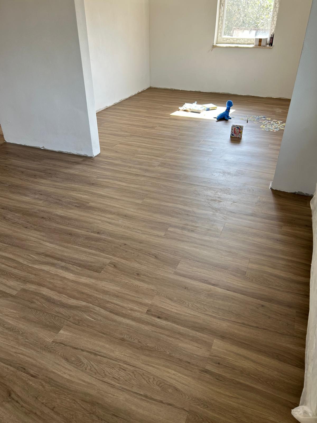 Verlegter Vinylboden in warmer Holzoptik über zwei verbundene Wohnräume